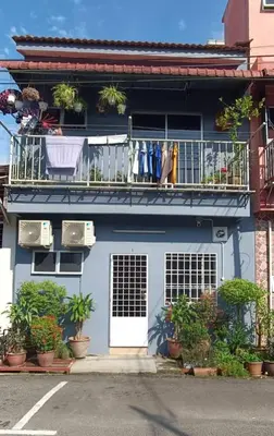 a blue house with a balcony with plants on it at Lenggong GEM 16 Homestay in Kampong Ulu Jepai