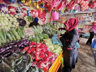 a woman standing in a grocery store selling vegetables at Keafarm Highland Breeze in Brinchang