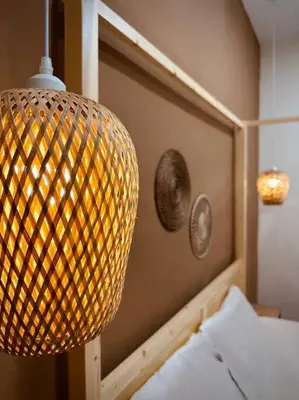 a lamp that is hanging over a bed at New Grand Muji Style Villa at Central Penang 16pax in Bukit Lada