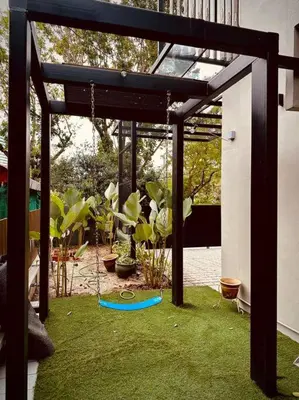 a wooden pergola with a swing in a yard at New Grand Muji Style Villa at Central Penang 16pax in Bukit Lada
