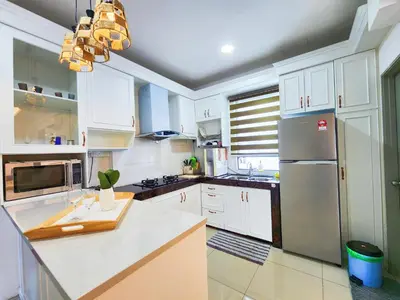 a kitchen with white cabinets and a stainless steel refrigerator at IPOH Apartmen Casa Kayangan Meru, Meru Raya 5 Ipoh Homestay in Ipoh