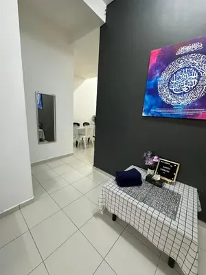 a room with a table and a painting on the wall at SakuZa Homestay in Slim River
