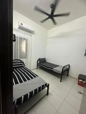 two beds in a room with a ceiling fan at SakuZa Homestay in Slim River