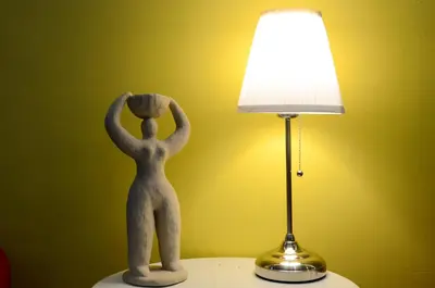 a statue of a person standing on a table next to a lamp at Ting Residence in Sitiawan