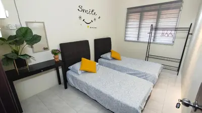 a bedroom with two beds with yellow pillows at 77 homestay 5Min to Leaning Tower in Teluk Intan