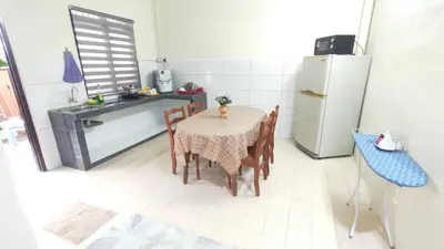 a kitchen with a table with chairs and a refrigerator at 77 homestay 5Min to Leaning Tower in Teluk Intan