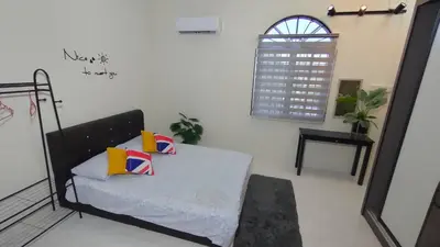 a room with a bed with pillows and a window at 77 homestay 5Min to Leaning Tower in Teluk Intan