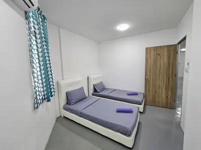 two beds in a room with a door at SS TWO Hostel Penang in George Town