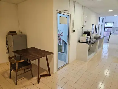 a kitchen with a wooden table and a refrigerator at SS TWO Hostel Penang in George Town