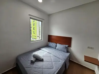 a bedroom with a bed and a window at New Mawlaya Hotel Penang in Gelugor