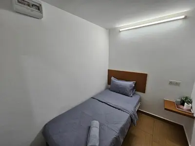 a small bedroom with a bed in a room at New Mawlaya Hotel Penang in Gelugor