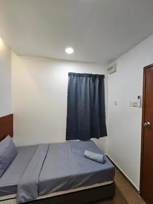 a small bedroom with a bed and a window at New Mawlaya Hotel Penang in Gelugor