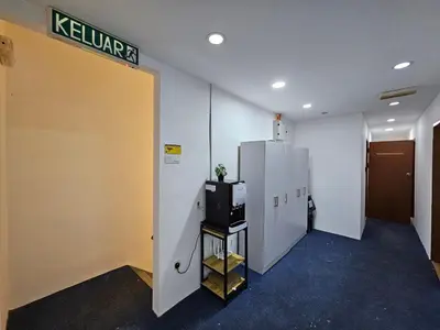 an office hallway with a tv and a door with a sign at New Mawlaya Hotel Penang in Gelugor