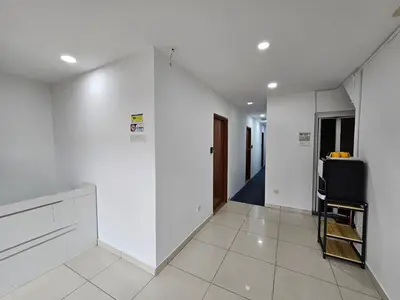 a hallway with white walls and a room with a tv at New Mawlaya Hotel Penang in Gelugor