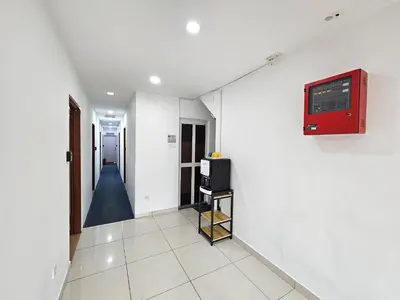a hallway with a tv on a white wall at New Mawlaya Hotel Penang in Gelugor