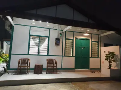 a small house with two chairs and a green door at Stay Meow Meow Mount Erskine Near Gurney Plaza, Adventist in George Town