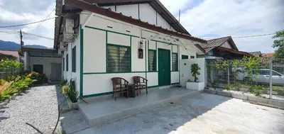 a small house with two chairs on the front porch at Stay Meow Meow Mount Erskine Near Gurney Plaza, Adventist in George Town