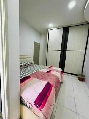 a bedroom with a bed with pink and purple blankets at AYAAN DELUXE HOMESTAY FREE WiFi in Cameron Highlands