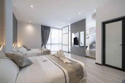 a large bedroom with two beds and a television at Saturn Hotel in George Town