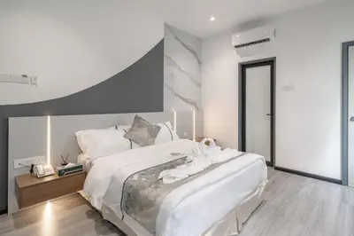 a bedroom with a large bed with white sheets at Saturn Hotel in George Town