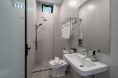 a white bathroom with a sink and a toilet at Saturn Hotel in George Town