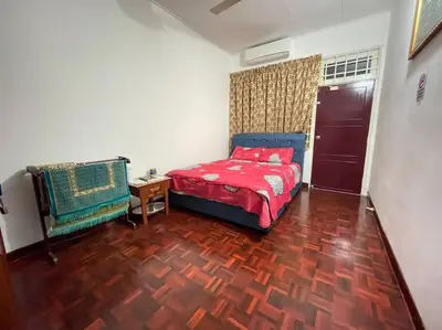 a bedroom with a red bed and a wooden floor at 4BR 2Storey Terrace Homestay at Bukit Jambul by SK Vacation Homes in Bayan Lepas