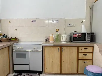 a kitchen with a stove and a microwave on a counter at 4BR 2Storey Terrace Homestay at Bukit Jambul by SK Vacation Homes in Bayan Lepas