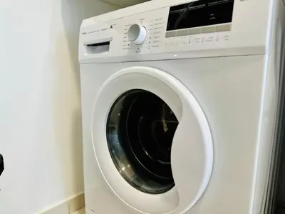 a white washing machine in a room at Beacon Executive Suites by WL in Kampong Makam