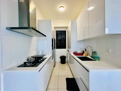 a white kitchen with a stove and a sink at Beacon Executive Suites by WL in Kampong Makam
