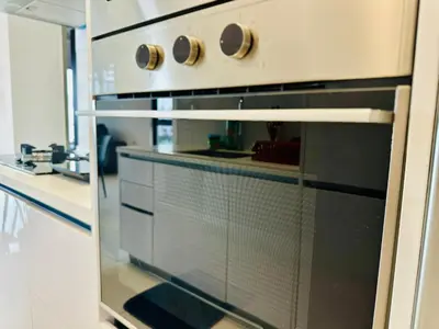 a kitchen with an oven with its door open at Beacon Executive Suites by WL in Kampong Makam