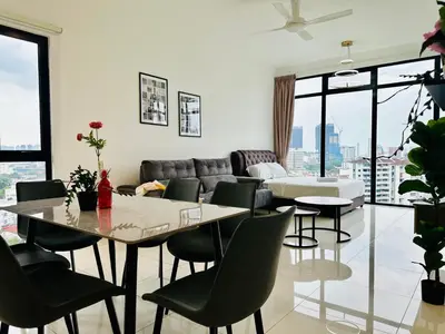 a living room with a table and chairs and a couch at Beacon Executive Suites by WL in Kampong Makam