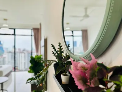 a mirror on a wall with some plants and flowers at Beacon Executive Suites by WL in Kampong Makam