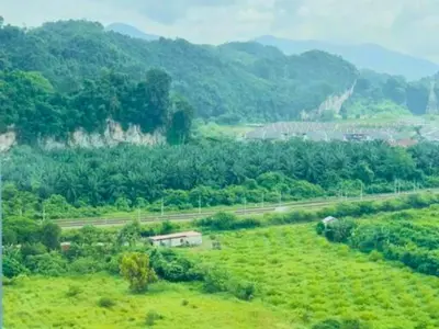 a green field with a house in the middle of it at The Anderson Haven Family Suites - Ipoh 2-bedroom Apartment in Ipoh