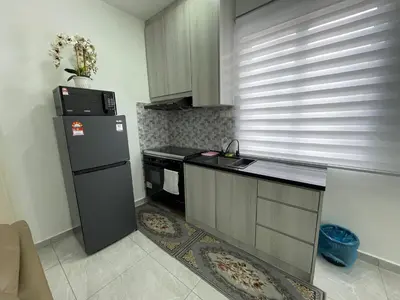 a kitchen with a refrigerator and a stove at Penang Studio Homestay at Kelawai Rd, Georgetown by SK Vacation Homes in George Town