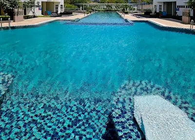 a large swimming pool with blue water at 3BR Condo at Gelugor by Hana Suite in Jelutong