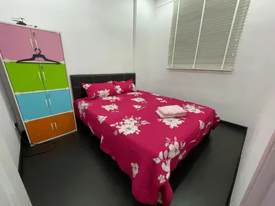a small bedroom with a bed with a pink blanket at 3BR Condo at Gelugor by Hana Suite in Jelutong
