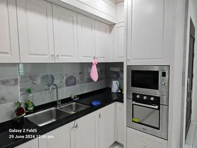 a white kitchen with a sink and a microwave at 3BR Condo at Gelugor by Hana Suite in Jelutong