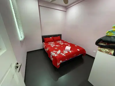 a small bedroom with a bed with red sheets at 3BR Condo at Gelugor by Hana Suite in Jelutong