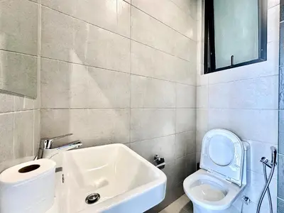 a bathroom with a white toilet and a sink at Family House In Georgetown a27 in Jelutong
