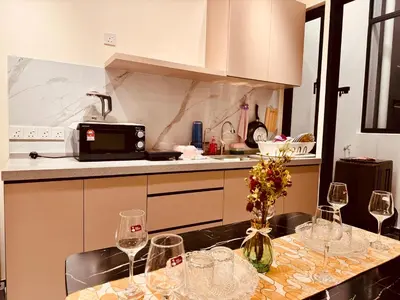 a kitchen with a table with wine glasses on it at Large Familystay 3BR Stunning Sea & City-view, Georgetown in Jelutong