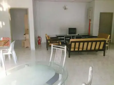 a living room with couches and a table with a television at Ria Cameron Hotel in Cameron Highlands