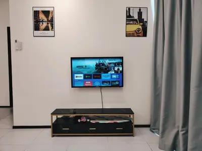 a flat screen tv sitting on top of a white wall at Premium Familystay Urban Suites-3BR 14 pax in Jelutong