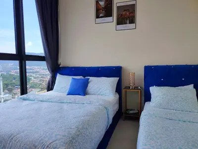 a bedroom with two beds with blue pillows and a window at Premium Familystay Urban Suites-3BR 14 pax in Jelutong