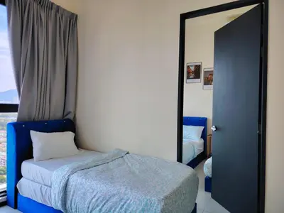 a bedroom with a blue bed and a mirror at world premium apartment 3BR pool sea view netflix 14pax a27 in Jelutong