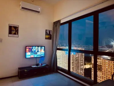 a room with a large window with a view of a city at world premium apartment 3BR pool sea view netflix 14pax a27 in Jelutong