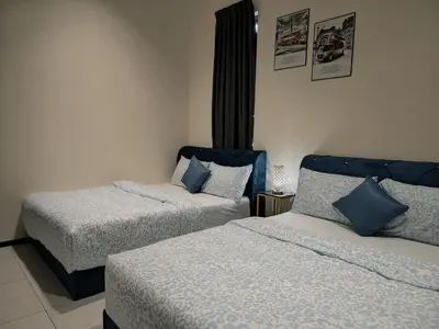 a hotel room with two beds with blue pillows at world premium apartment 3BR pool sea view netflix 14pax a27 in Jelutong