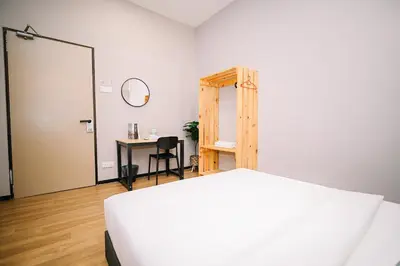 a bedroom with a bed and a desk and a mirror at Swing & Pillows - 87 Chulia St, Georgetown Penang in George Town