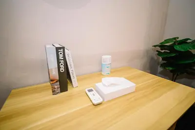 a wooden table with a remote control and a book at Swing & Pillows - 87 Chulia St, Georgetown Penang in George Town