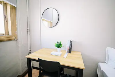 a small table with a mirror and a table with chairs at Swing & Pillows - 87 Chulia St, Georgetown Penang in George Town