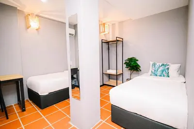 a small room with two beds and a mirror at Swing & Pillows - 87 Chulia St, Georgetown Penang in George Town